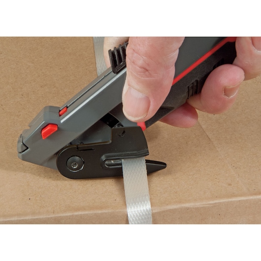 STANLEY 0-10-242 photography of hand-held strap cutter tool on cardboard box.