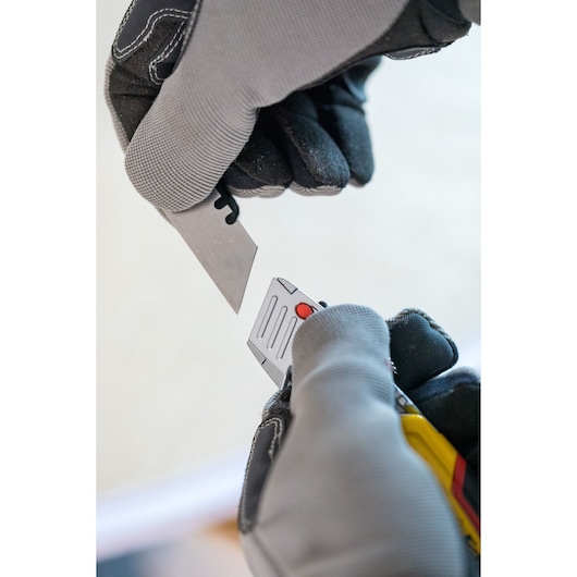 STANLEY 0-10-825 utility knife blade replacement shown with gloved hands, close-up photo.