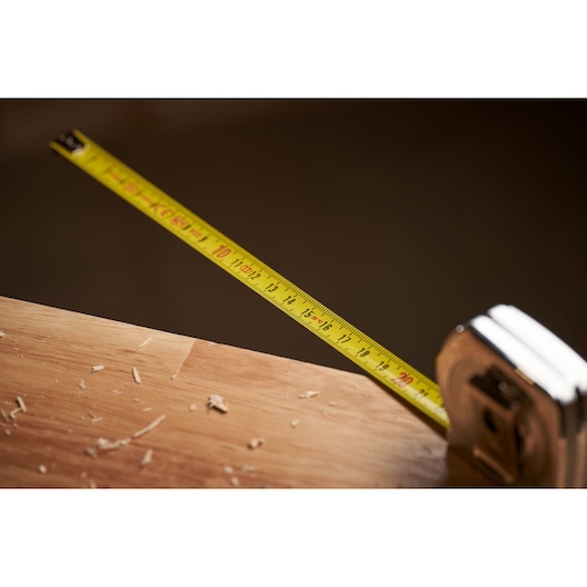 STANLEY 0-33-238 tape measure with yellow blade extended on wooden surface, close-up photography.