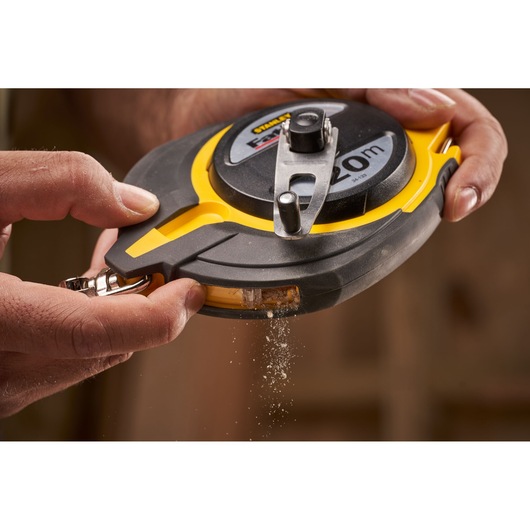 STANLEY 0-34-133 chalk line reel with yellow and black case, close-up in use, chalk powder dispensing.