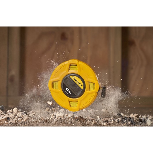 STANLEY 0-34-296 yellow 20m tape measure photography with rugged case on construction debris.