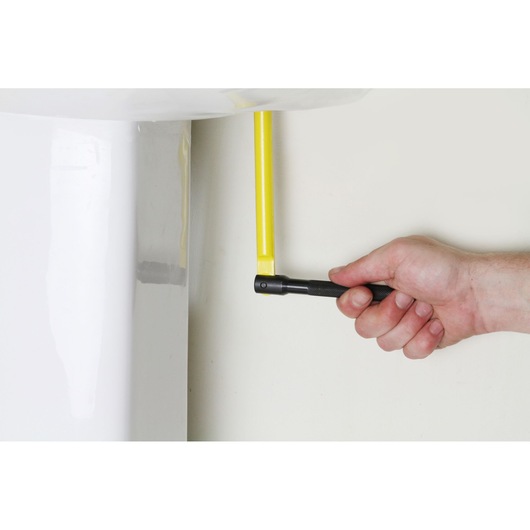 STANLEY 0-70-453 angle adaptor being used to tighten a yellow bolt near a white fixture, close-up.
