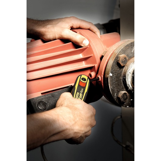 Photo of STANLEY 0-97-553 insulated screwdriver in use tightening a screw on industrial machinery.