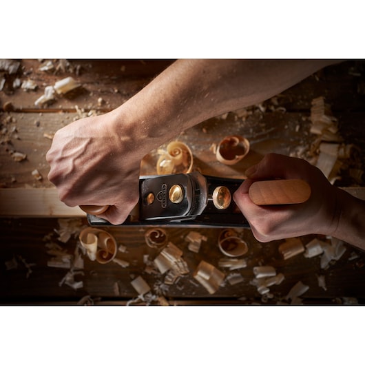 STANLEY 1-12-136 hand plane in use on wood, photography category, top view with wood shavings.