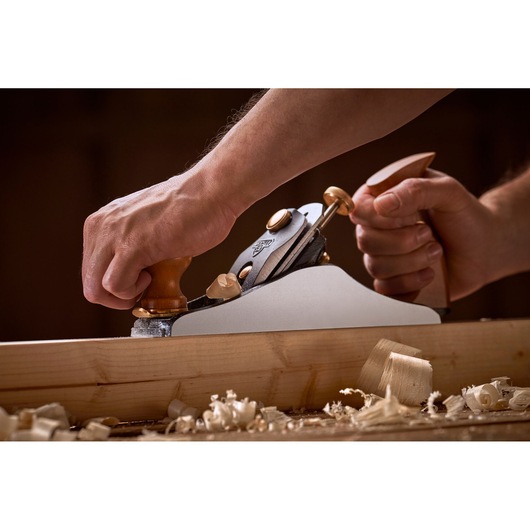 Photo of STANLEY 1-12-136 hand plane in use on wood, close-up view with wood shavings.
