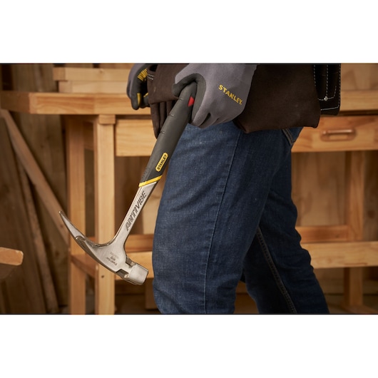 STANLEY 1-51-937 hammer with anti-vibe handle held in gloved hand in workshop setting.