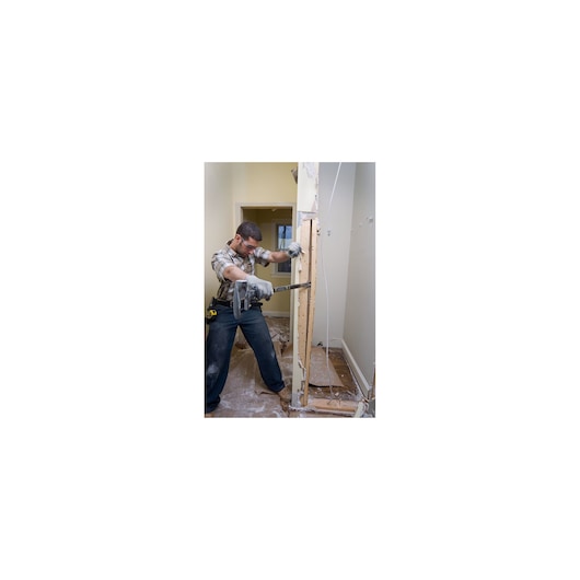 Photo of person using STANLEY 1-55-120 wrecking bar during interior wall demolition, tool belt visible.