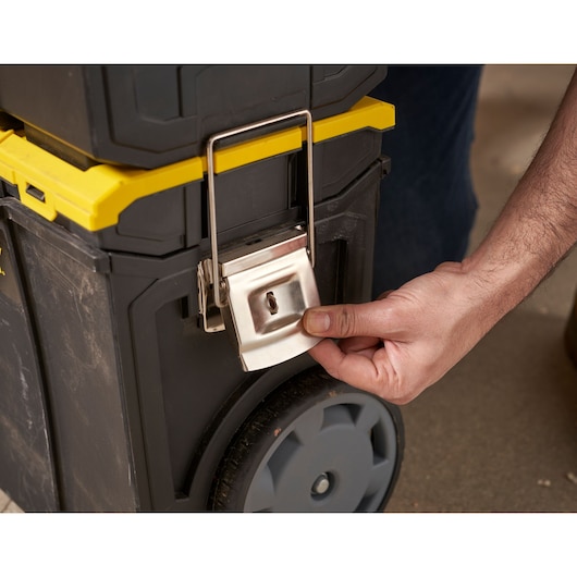 STANLEY 1-70-326 tool box close-up, showing large metal latch being opened by hand, black and yellow design.