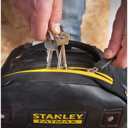 STANLEY 1-79-215 tool bag close-up with keys held above yellow zipper, FATMAX logo visible.