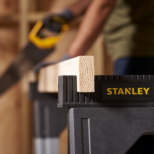 STANLEY 1-92-980 sawhorse holding a wooden beam in a workshop setting, photography close-up.