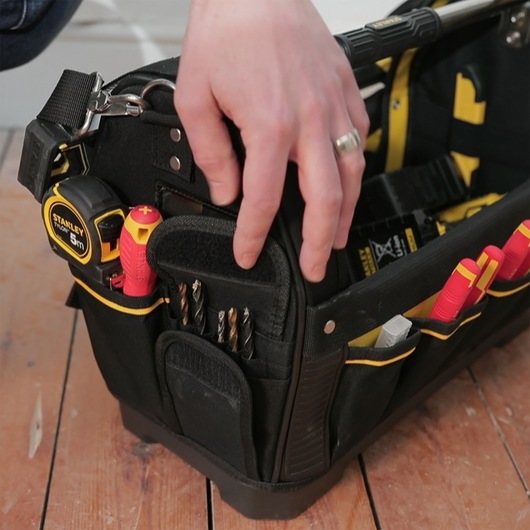 STANLEY 1-93-951 photography of a black tool bag with hand, tape measure, screwdrivers, and drill bits.