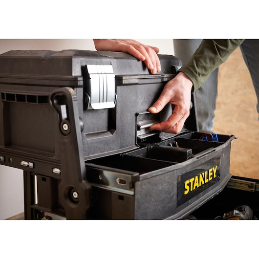 STANLEY 1-94-210 tool box being opened, close-up of hands unlocking black plastic organizer.