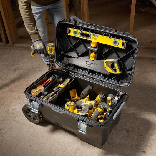 STANLEY 1-94-850 rolling tool chest open, filled with hand tools and power tools on construction site.