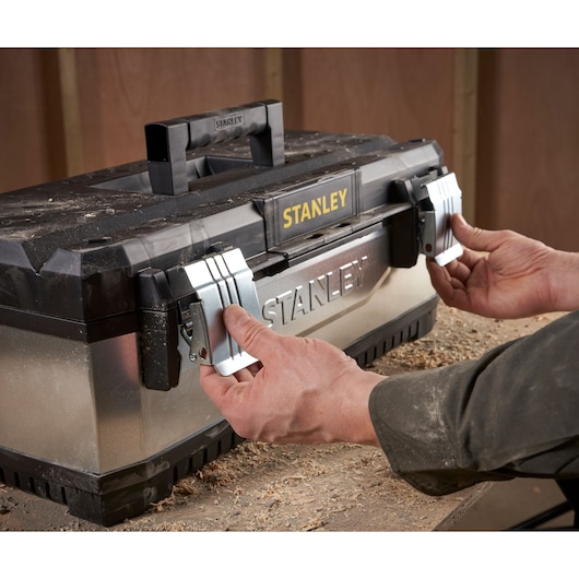 STANLEY 1-95-619 metal toolbox with black lid being opened by hands, photo from front angle.