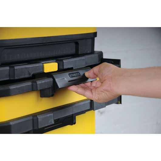 STANLEY 1-95-621 tool box stack with hand pulling front handle, close-up photography.