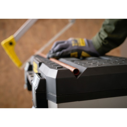STANLEY 1-95-622 toolbox top used to cut pipe with saw, close-up angle.