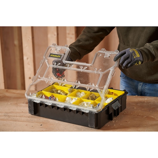 STANLEY 1-97-521 organizer with clear lid, black base, and yellow compartments, shown open on a workbench.
