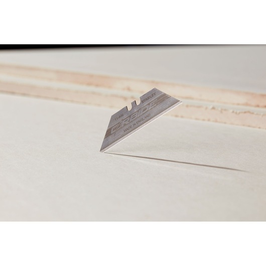 STANLEY 2-11-800 utility blade, silver color, close-up side angle on light surface.