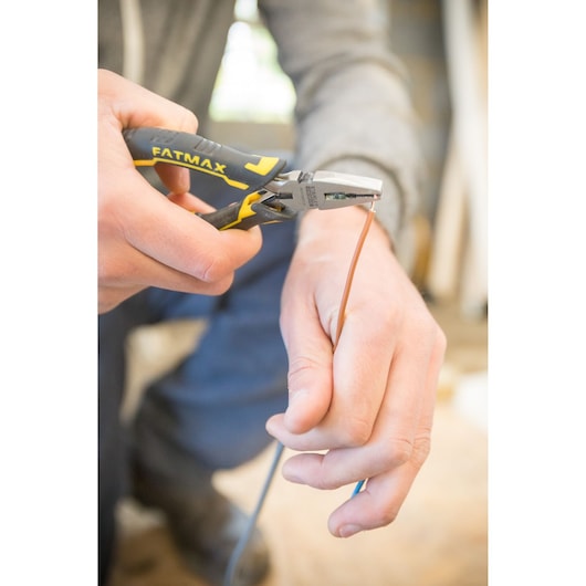 STANLEY FMHT0-80516 FATMAX pliers cutting wire, close-up photo, tool held by hand, photography category.