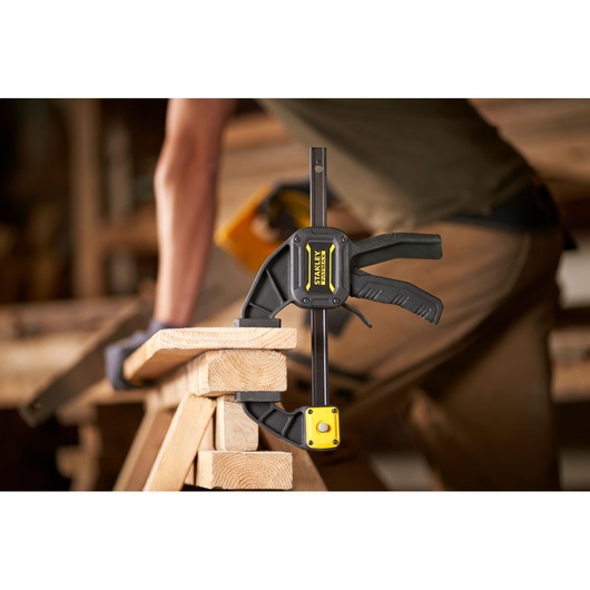 STANLEY FMHT0-83234 clamp holding wood in a workshop, close-up side view.
