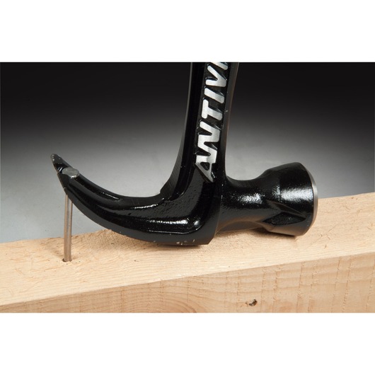 STANLEY FMHT1-51277 claw hammer side view removing nail from wood plank.