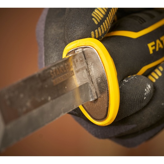 STANLEY FMHT16693-0 chisel held by a gloved hand, close-up of yellow and black handle and blade.
