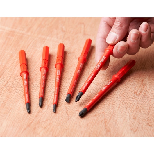 Photo of STANLEY FMHT66426-0 insulated screwdriver set, six red-handled screwdrivers on wooden surface.