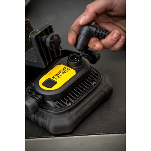 Photo of STANLEY FMHT81507-1 digital inflator being connected with power cable, close-up view.