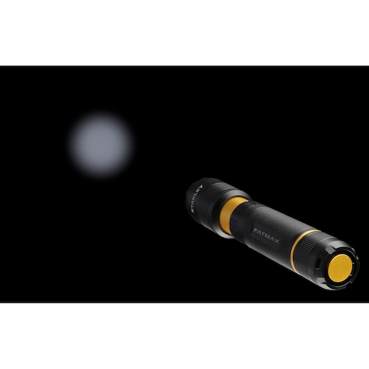 STANLEY FMHT81511-0 black and yellow flashlight side angle with beam visible in darkness.