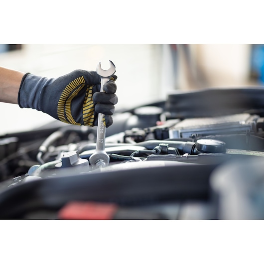 STANLEY FMMT13065-0 spanner used on car engine by gloved hand, close-up, product in use.