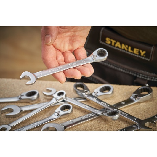 Photo of STANLEY FMMT13081-0 ratcheting wrench set, silver, held in hand with other wrenches on table.