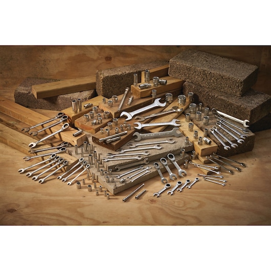 STANLEY FMMT17210-0 assortment of wrenches and sockets displayed on wood and bricks, angled front view.