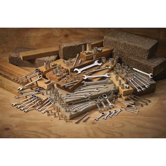 STANLEY FMMT17231-0 hand tool assortment with wrenches and sockets on wood and concrete blocks.