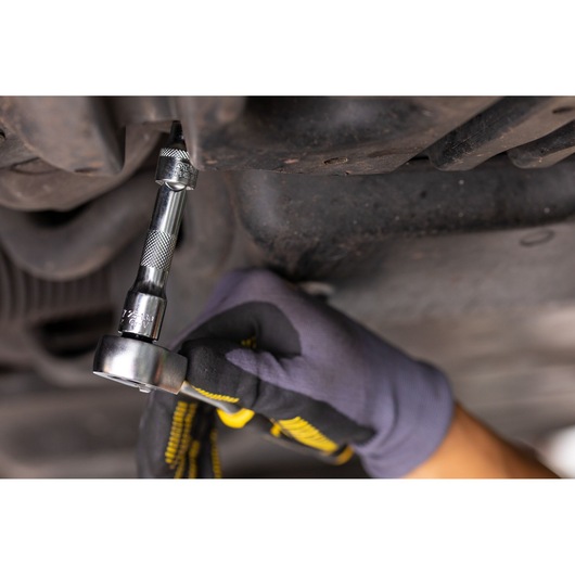 STANLEY FMMT25125-0 socket wrench in use on a bolt, close-up, automotive repair, gloved hand.
