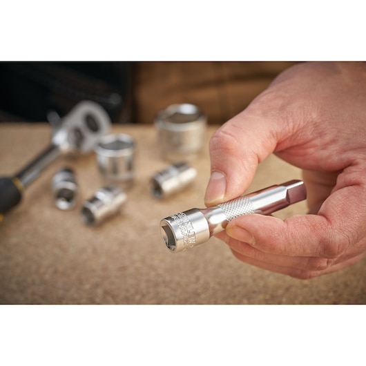 Photo of STANLEY FMMT25130-0 socket extension held in hand with sockets in background.