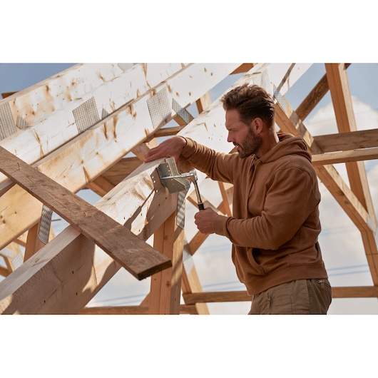 STANLEY hammer and framing accessories used for construction on wooden roof beams, outdoor setting.
