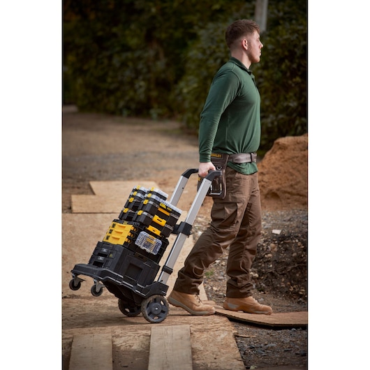 STANLEY FMMT98101-0 stackable toolboxes on trolley cart, outdoor worksite, side view.