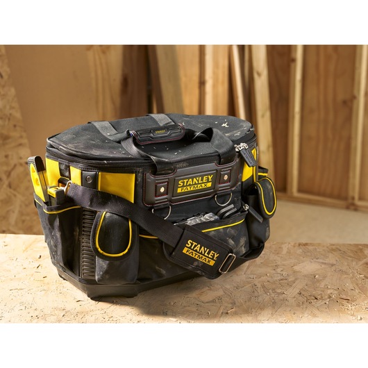 Stanley FMST1-70749 tool bag, black and yellow fabric, FatMax logo, sturdy base, shoulder strap, in workshop.