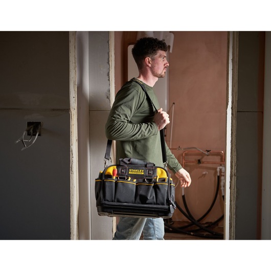 Stanley FMST1-73607 tool bag with shoulder strap and tools, photography in a construction setting.