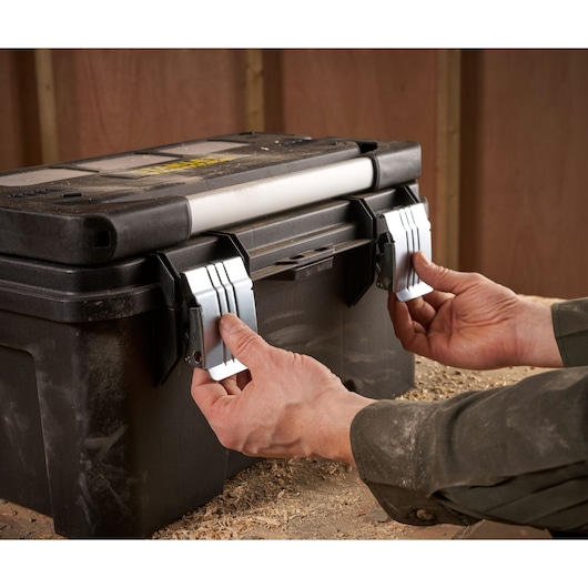 STANLEY FMST1-75792 toolbox photography, black plastic case with metal latches, handling close-up.