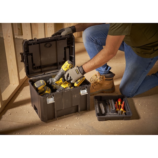 STANLEY FMST1-75796 tool box, open, filled with power tools and hand tools, indoor workshop setting.