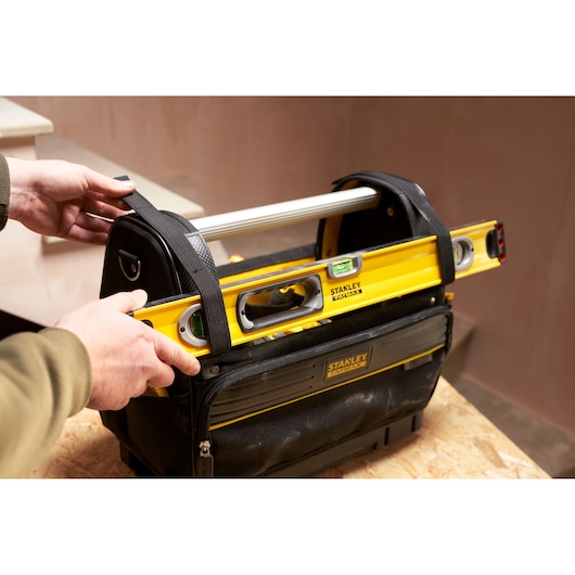 STANLEY FMST17626-1 tool bag with yellow STANLEY level, black fabric handle, side front view.