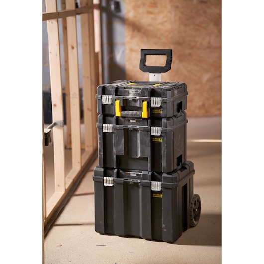 STANLEY FMST75753-9 stackable wheeled toolbox with handle shown in a workshop setting.