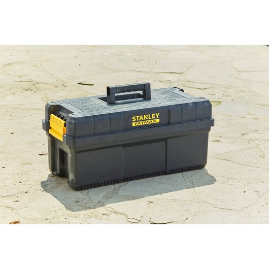 STANLEY FMST81083-1 toolbox, black plastic with yellow latches, outdoor angle photography.