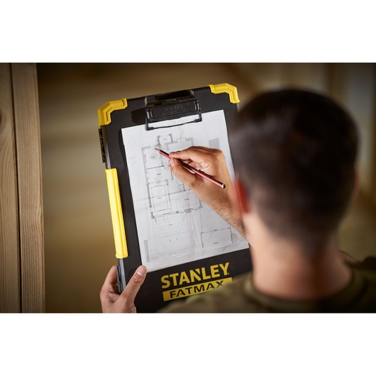 STANLEY FMST82721-1 clipboard with yellow handle, held by person marking architectural plan.