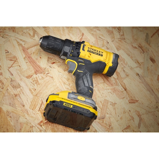 STANLEY SFMCD700C2K cordless drill, yellow and black, angled view on wooden surface.