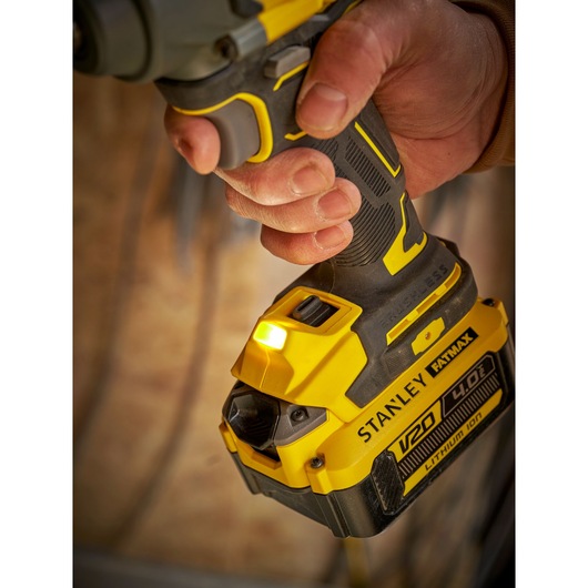 Close-up of STANLEY SFMCF920B cordless impact driver with yellow and black V20 Lithium-Ion battery.