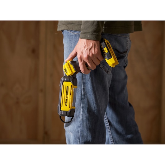 STANLEY SFMCL050B 18V FATMAX V20 pivot light held in hand, yellow and black, photography product.