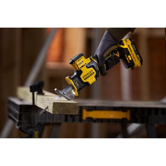 STANLEY SFMCS305B cordless reciprocating saw cutting wood, close-up photography of product in use.