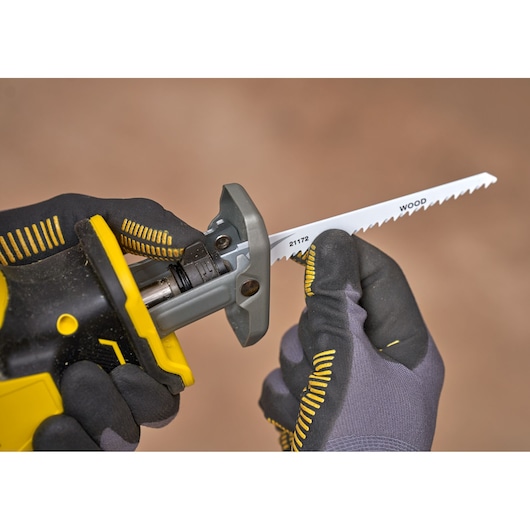STANLEY SFMCS305B reciprocating saw with wood blade installation, close-up photo with gloved hands.